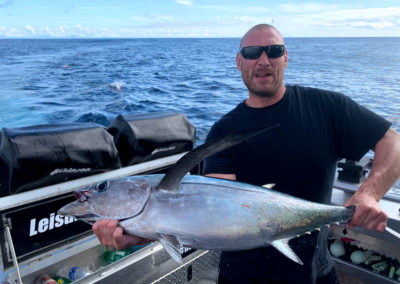 man holding freshly caught tuna fish